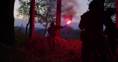 Yoğun ormandaki askeri harekat sırasında işaret fişeği kullanan bir grup asker.