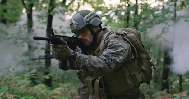 A katonák puskából lőnek az erdőben, füst a háttérben, katonai és katonai koncepció. — Stock videók