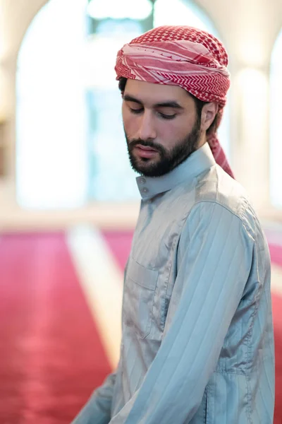 Um muçulmano termina uma oração virando a cabeça para o lado,. — Fotografia de Stock