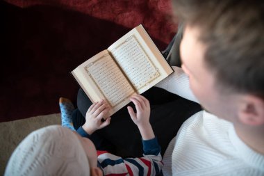  Baba oğul camide dua ediyor ve kutsal kitap Kuran 'ı birlikte okuyorlar. İslam eğitimi kavramı.
