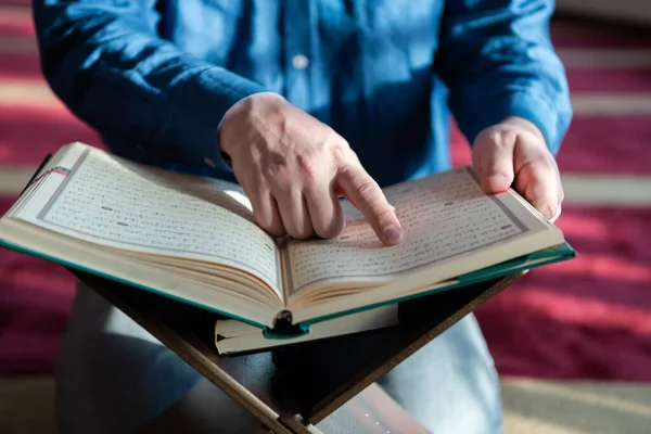 Muslim man be Allah ensam inne i moskén och läsa islamisk järnek bok — Stockfoto