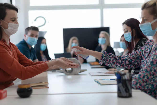 Nuevos empresarios normales en reunión usando desinfectante antibacteriano de la mano —  Fotos de Stock
