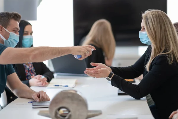 Novos empresários normais em reunião usando antibacteriano higienizador da mão — Fotografia de Stock