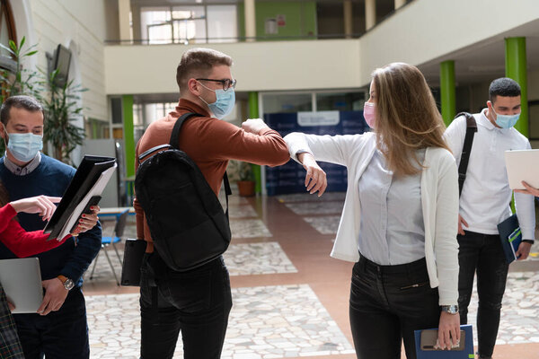 students greeting new normal coronavirus handshake and elbow bumping