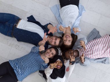 Zeminde yatan ve birlikteliği sembolize eden bir grup insanın üst görüntüsü..