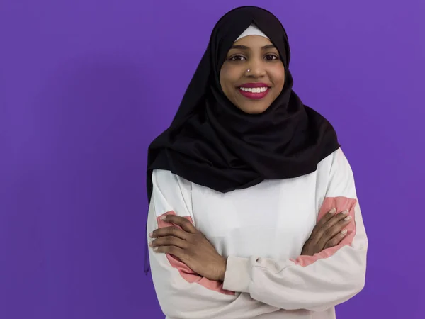 Potret wanita muslim afrika mengenakan jilbab dan pakaian tradisional muslim berpose di depan latar belakang ungu — Stok Foto