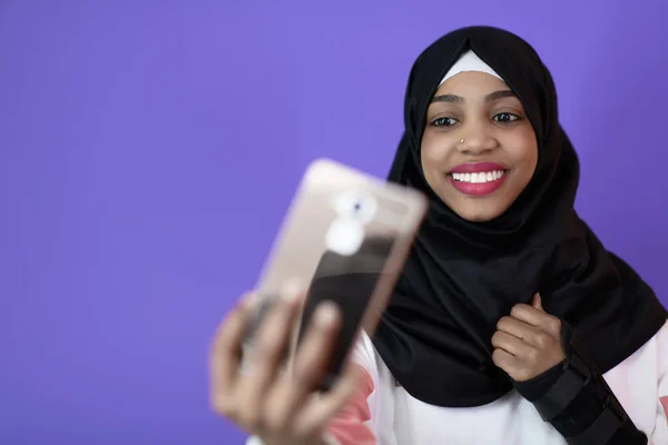 Güzel gülüşlü Afrikalı Müslüman kadın cep telefonuyla selfie çekiyor. — Stok fotoğraf