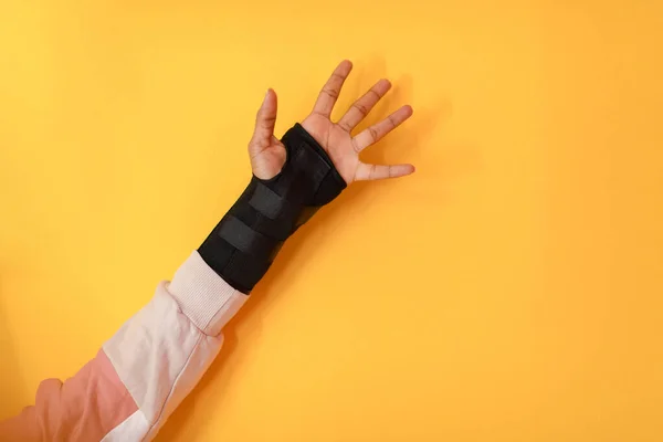 Handblessure. een vrouwelijke gewonde hand op een gele achtergrond — Stockfoto