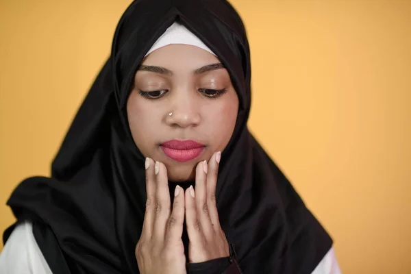 Afrikanische Muslimin in Hijab und traditioneller muslimischer Kleidung posiert vor grünem Hintergrund — Stockfoto