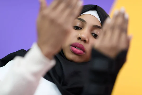 Afrikansk muslimsk kvinna bär hijab och traditionella muslimska kläder poserar framför grön bakgrund — Stockfoto