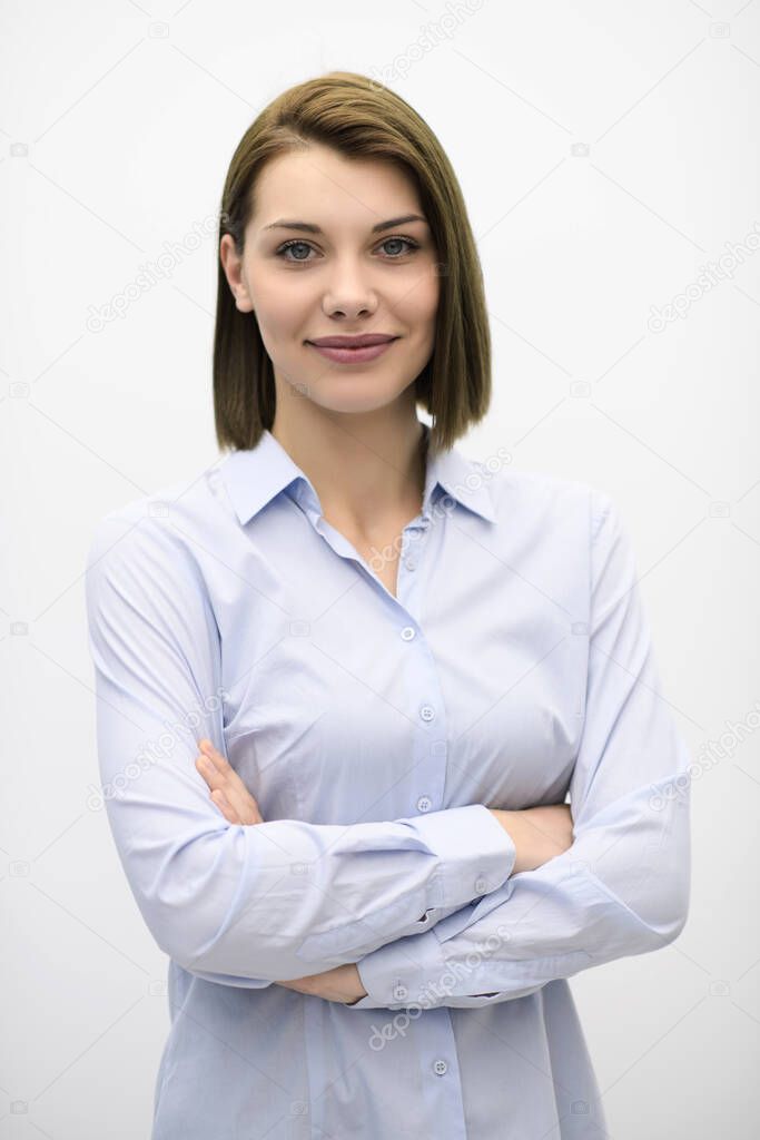 Portrati shot of beautiful blond businesswoman standing with arms crossed at isolated white background.