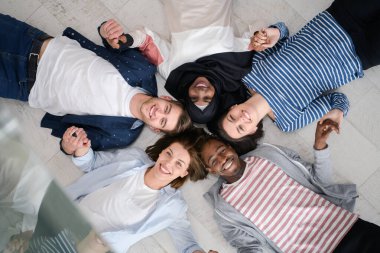 Zeminde yatan ve birlikteliği sembolize eden bir grup insanın üst görüntüsü..