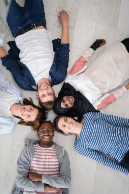 Zeminde yatan ve birlikteliği sembolize eden bir grup insanın üst görüntüsü..