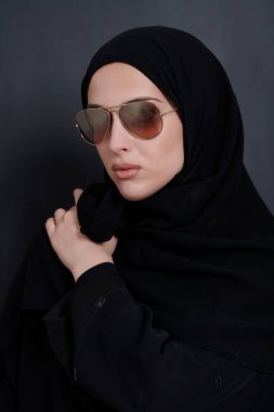 Geleneksel giysiler içinde genç Müslüman iş kadını ya da abaya ve siyah karatahtanın önünde poz veren güneş gözlüğü. Modern Arap yaşam tarzını, İslami modayı ve Ramazan kareemini temsil eden Arap kadını