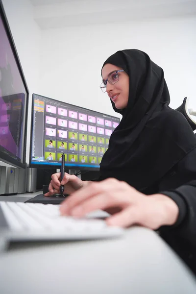 穆斯林女性平面设计师在电脑上使用图形平板电脑和两个监视器 穿着头巾在办公室里编辑照片的女孩 — 图库照片
