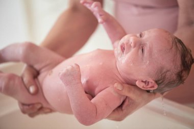 Anne banyo yapıyor. Yeni doğmuş bebek banyo yapıyor.
