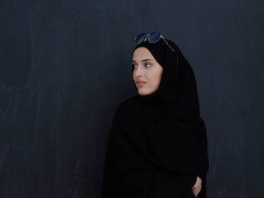 Geleneksel kıyafetli genç Müslümanlar ya da abaya ve siyah karatahtanın önünde poz veren güneş gözlükleri. Modern Arap yaşam tarzını, İslami modayı ve Ramazan kareem kavramını temsil eden Arap kadını