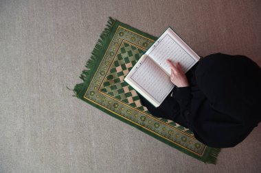 Orta Doğulu kadın Kuran okuyup namaz kılıyor.