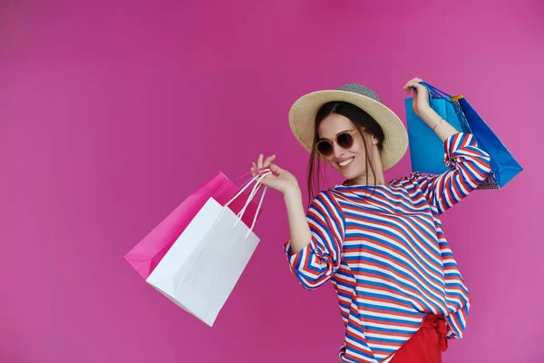 ピンクの背景にショッピングバッグを持つ若い女性 大販売の1日後に新しい購入でポーズをとっている幸せな女の子 ブラック フライデーのコンセプト — ストック写真
