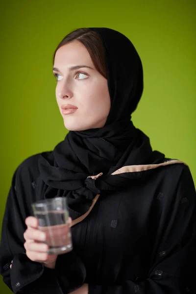Mulher do Oriente Médio em Abaya segurando um copo de água — Fotografia de Stock