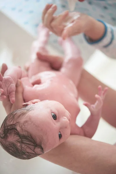 Новорожденная девочка принимает ванну — стоковое фото