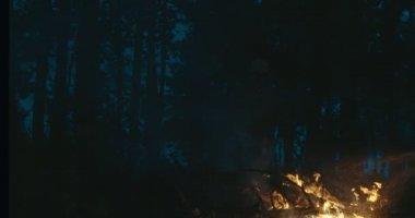 Yangın söndürme ekipmanları ve balta ile gece ormanda yangın söndüren itfaiyeci