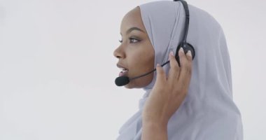 Afrikalı Müslüman müşteri temsilcisi kulaklıklı iş kadını müşteriyle çevrimiçi olarak yardım ve destek veriyor