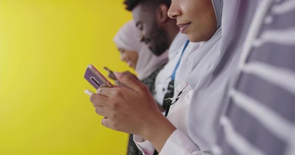 Afrikaanse studenten groep met behulp van smartphones over gele achtergrond — Stockvideo
