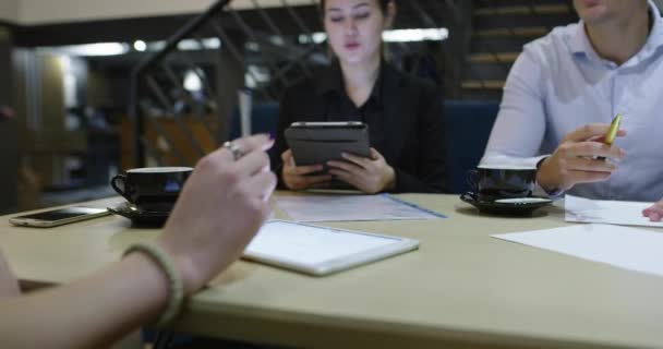 Gropu van zakenmensen ontmoeten in cafe en werken aan project close-up op handen — Stockvideo