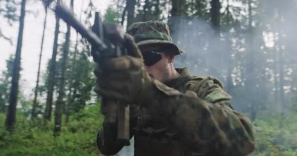 Moderne soldaat met geweer in het holenbos met rook in de rug — Stockvideo