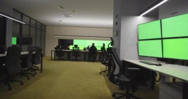 Boş ofis, masa ve sandalyeler yeşil ekran ve krom anahtarlı ana CCTV güvenlik veri merkezinde.