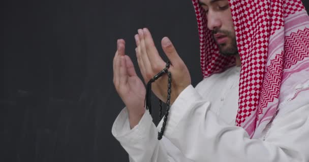 Μέση Ανατολή αραβική άνθρωπος με παραδοσιακά ρούχα μπροστά από το μαύρο μαυροπίνακα προσεύχεται — Αρχείο Βίντεο