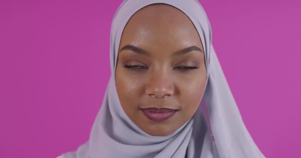 Jonge moderne moslim afro schoonheid dragen traditionele islamitische kleding op plastic roze achtergrond — Stockvideo