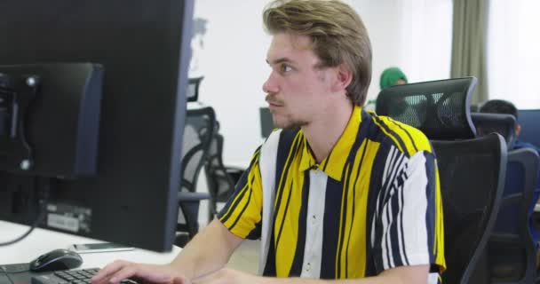 Бізнесмен працює за своїм настільним комп'ютером, сидячи в стартапі — стокове відео