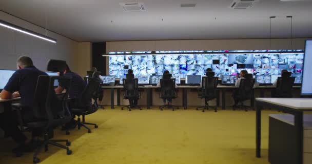 Operadores de sala de controle de segurança trabalhando em instalações de vigilância de segurança de ponta — Vídeo de Stock