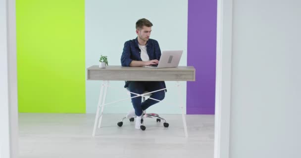 Serbest kariyer, gülen adam evde dizüstü bilgisayarda çalışıyor. — Stok video