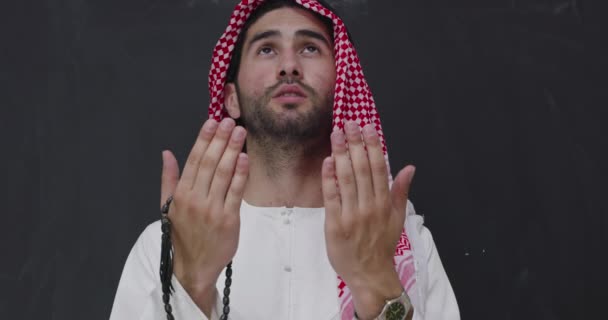 Moslem Mann in traditioneller Kleidung vor schwarzer Tafel betet Allah mit weit geöffneten Händen — Stockvideo