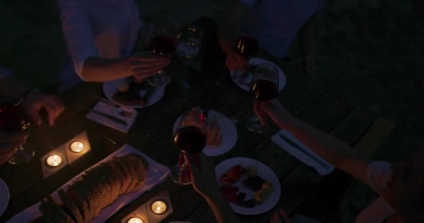 Concept d'amitié des jeunes - Mains griller verre de vin rouge au bord de la rivière la nuit — Video