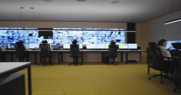Beveiligingsbeambten kijken naar videobewaking bewakingssysteem im moderne faciliteit met high-end beveiligingssystemen en technologie — Stockvideo