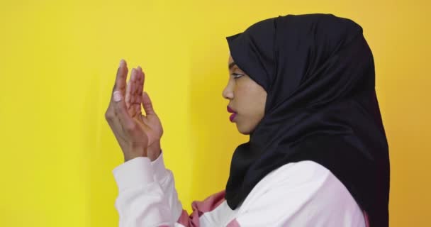 Vacker afrikansk amerikansk flicka bär muslim hijab över färg bakgrund — Stockvideo
