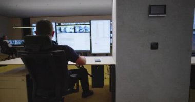 Güvenlik görevlileri gözetleme odasındaki kameraları izliyorlar.