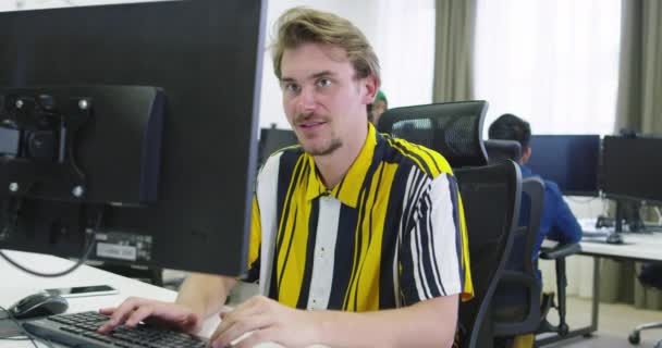 Businessman working at his desktop computer sitting at his desk in the open space startup office — Stock Video