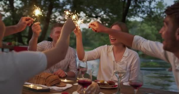 Ifjúsági barátság koncepció - Kezek pirító vörösbor üveg mellett folyó éjjel — Stock videók