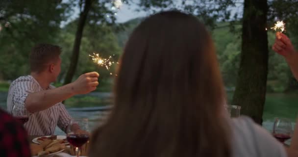 Ifjúsági barátság koncepció - Kezek pirító vörösbor üveg mellett folyó éjjel — Stock videók