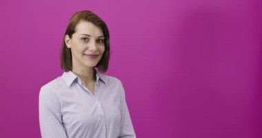 Pembe arka planda izole edilmiş, gülümseyen ve eğlenen genç kadın portresi