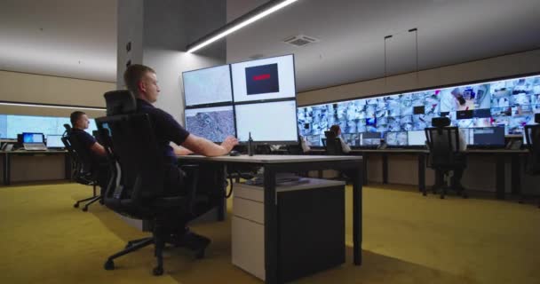 Guardas de segurança monitorando câmeras de CCTV modernas na sala de vigilância — Vídeo de Stock