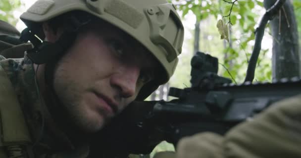 Soldado de fusil totalmente equipado con uniforme de camuflaje que ataca al enemigo, rifle en posición de disparo en bosque denso — Vídeos de Stock