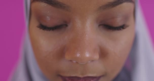 Gros plan de la jeune beauté afro musulmane moderne portant des vêtements islamiques traditionnels sur fond rose en plastique — Video