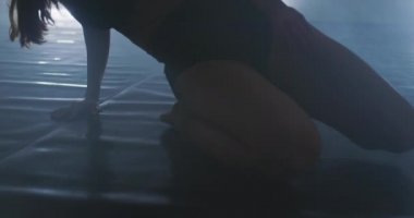 Çağdaş bale dansçısı dumanlı bir atmosferde pratik yapıyor, ince esnek bir dans sanatçısı.