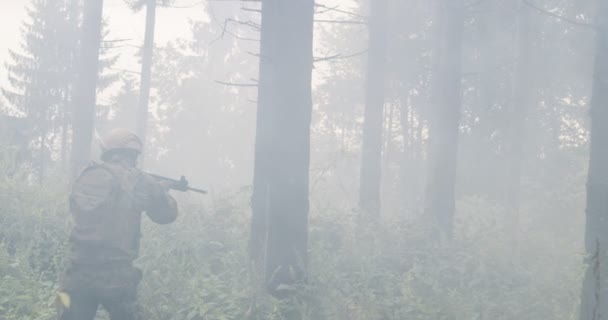 士兵带着准备射击的来复枪穿过烟雾弥漫的森林 在军事行动期间穿过森林 — 图库视频影像